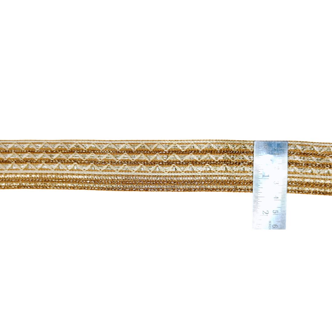 Gold thread with a ruler for measurement on a white background