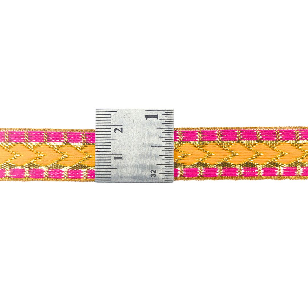 Woven belt with pink and yellow pattern and a ruler for scale on a white background