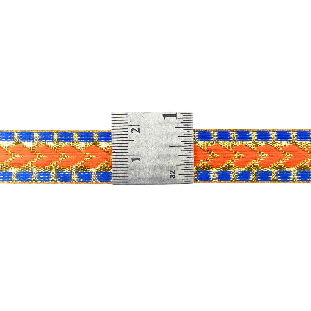 Bracelet with orange and blue pattern and a ruler for size reference on a white background