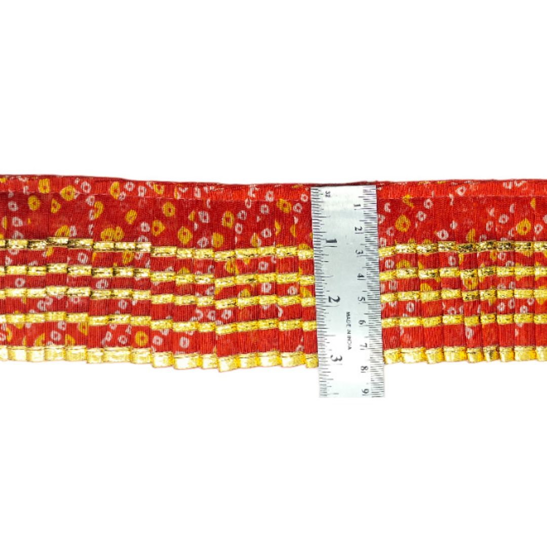 Red and yellow floral fabric with a ruler for scale on a white background