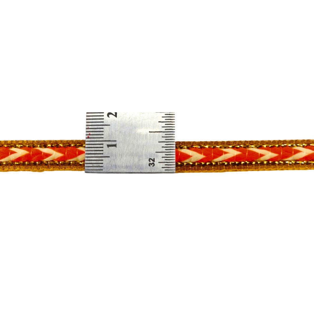 Red and gold ribbon with a ruler for scale on a white background