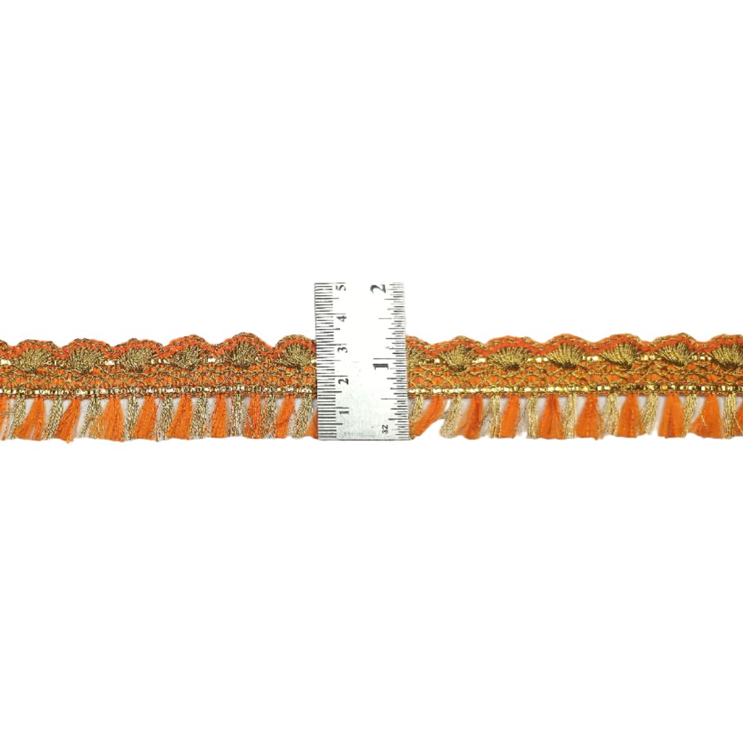 Decorative orange lace trim with a ruler for scale on a white background