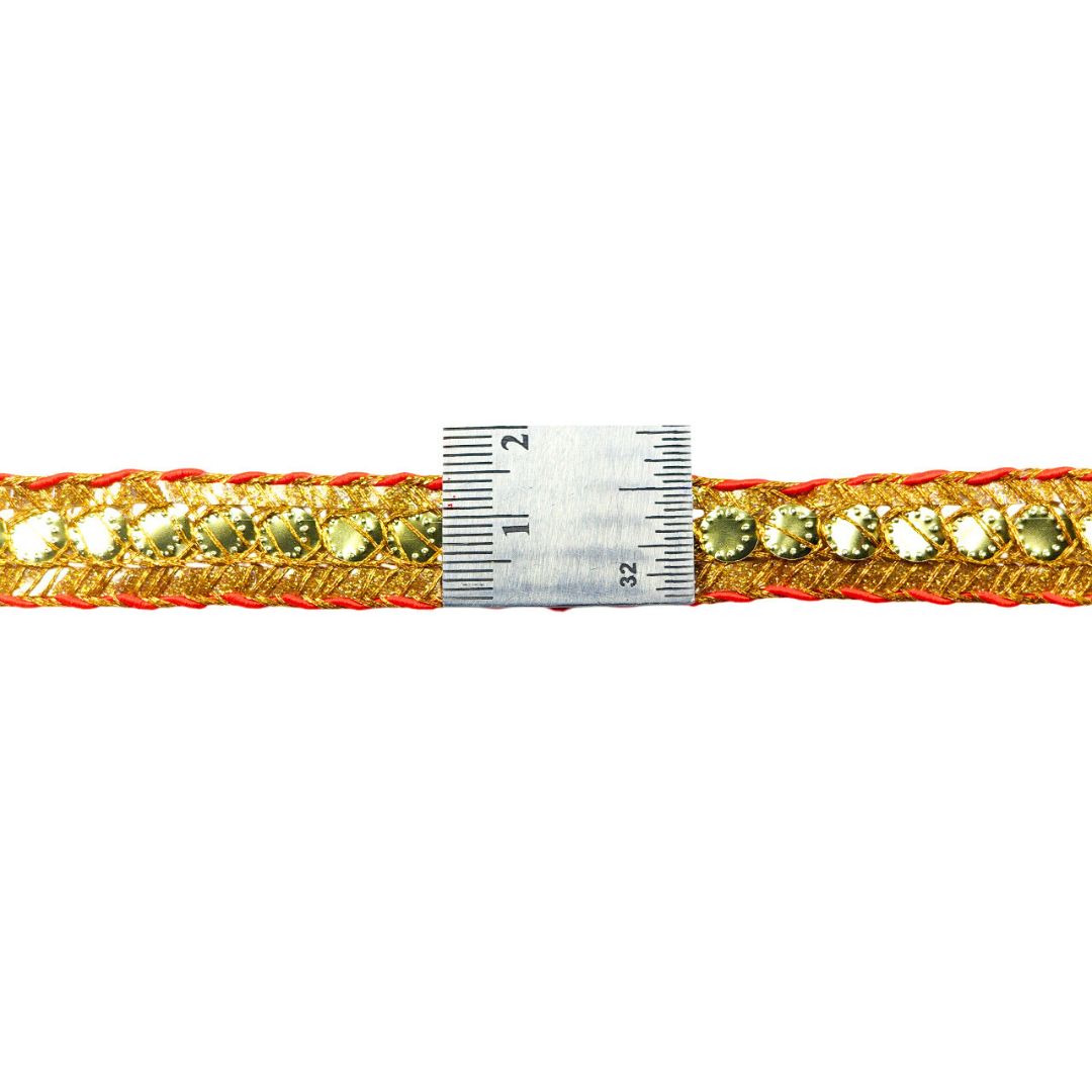 Decorative ribbon with gold and red colors and a ruler for scale on a white background