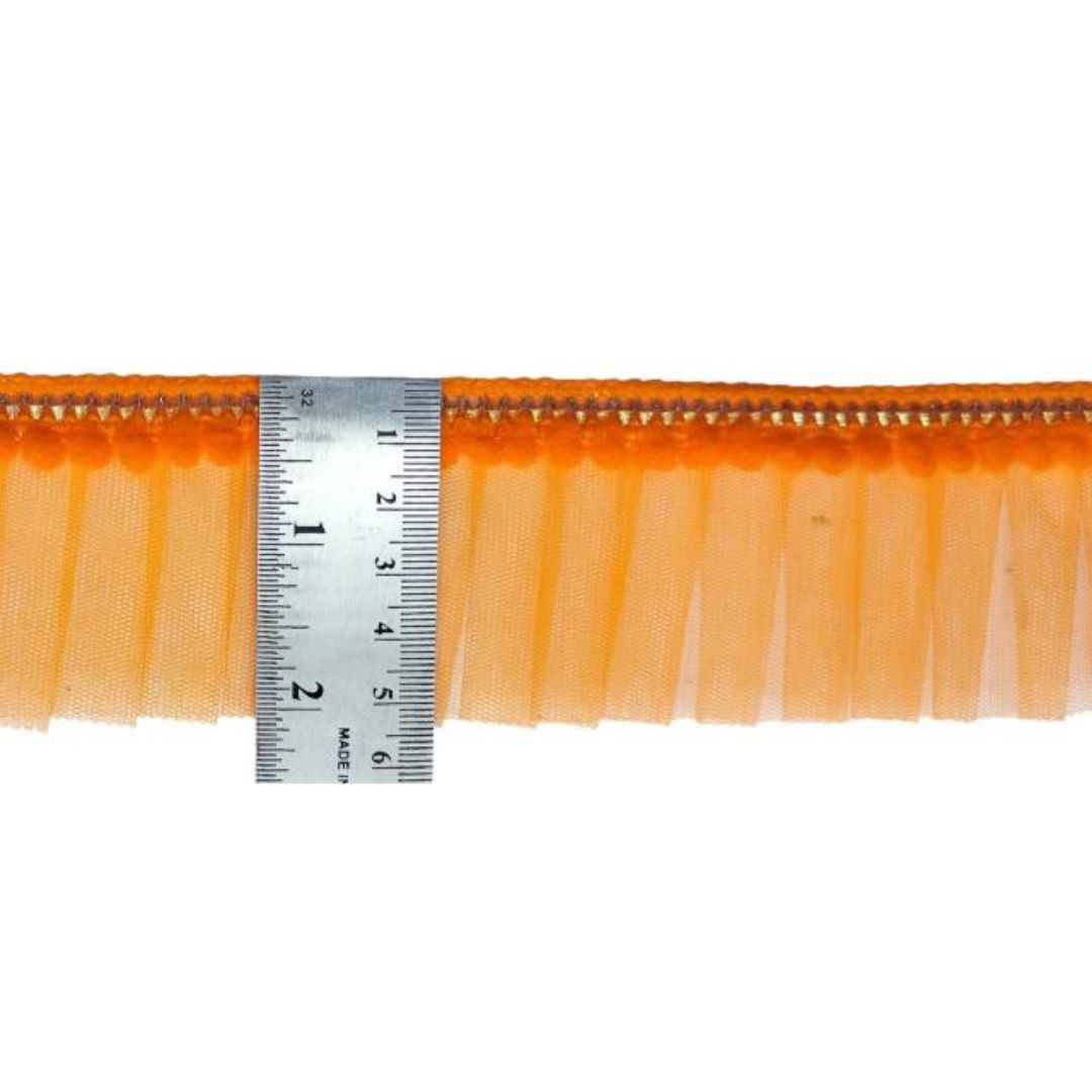Orange fringe trim with a ruler for measurement on a white background