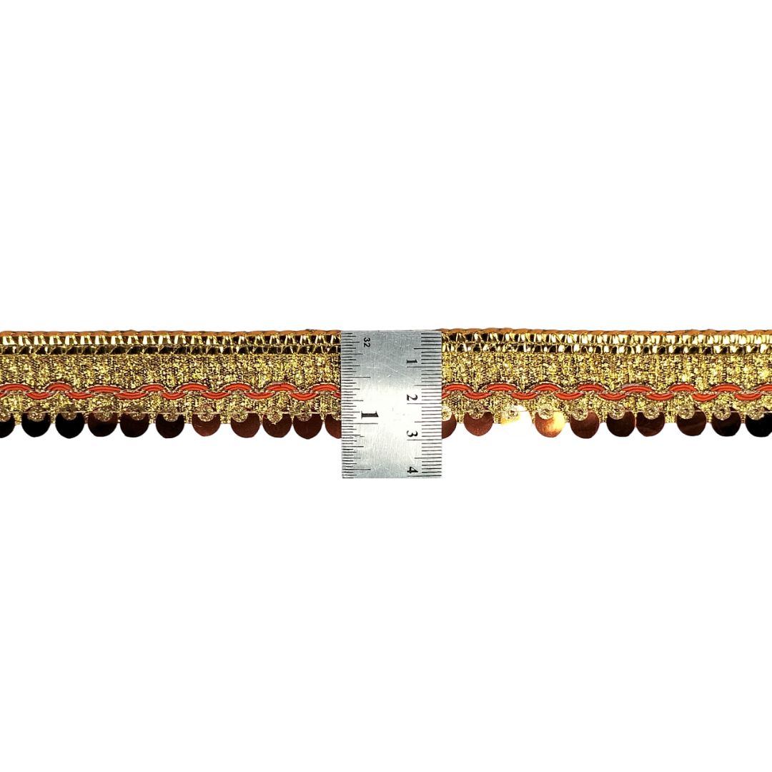 Gold lace trim with a ruler for measurement on a white background