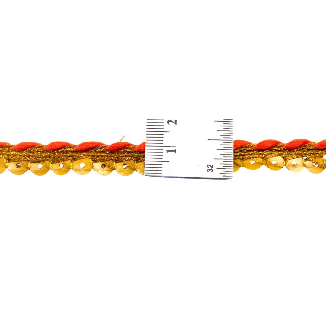 Close-up of red and gold braided cord with a ruler for scale on a white background