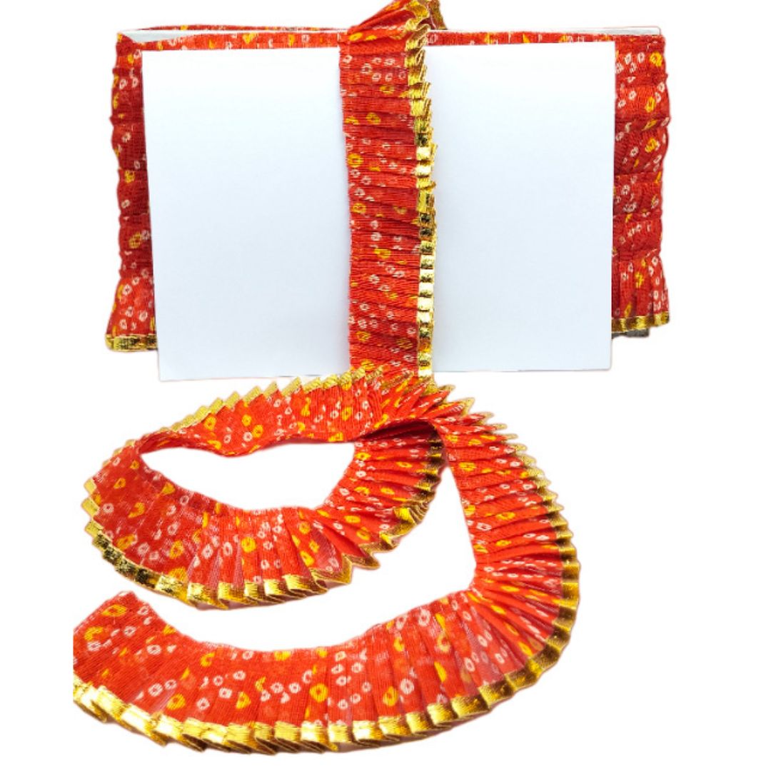 Red and yellow patterned fabric with a white card on a white background