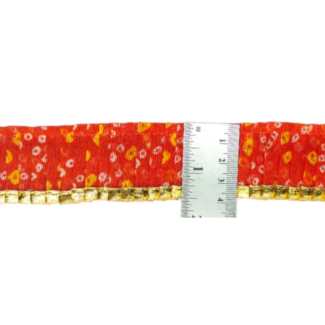 Red fabric with floral pattern and a measuring tape on a white background