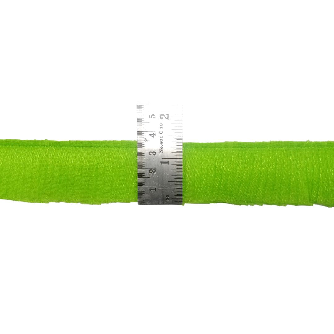 Green yarn with a ruler for scale on a white background