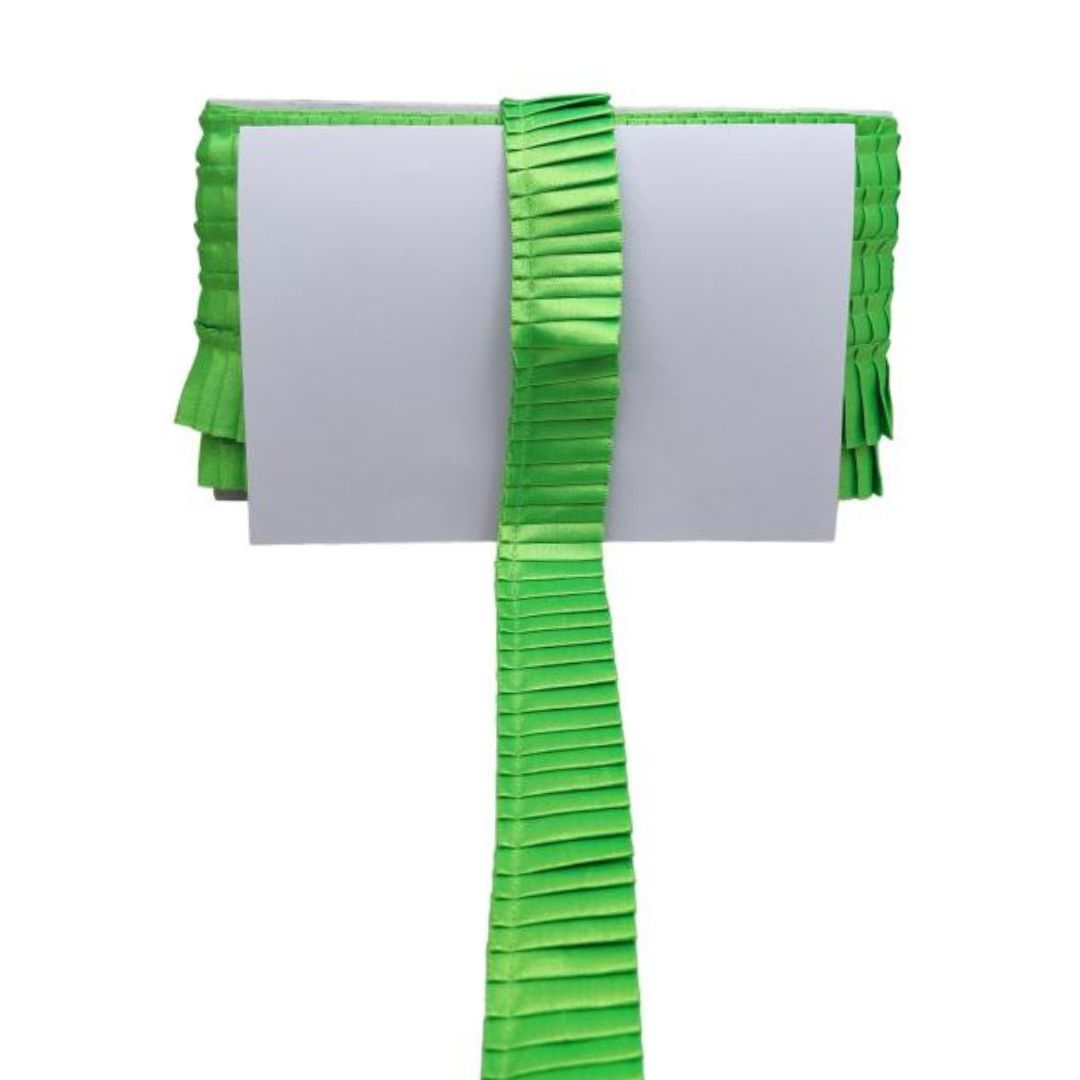 Green pleated ribbon with a white card on a white background