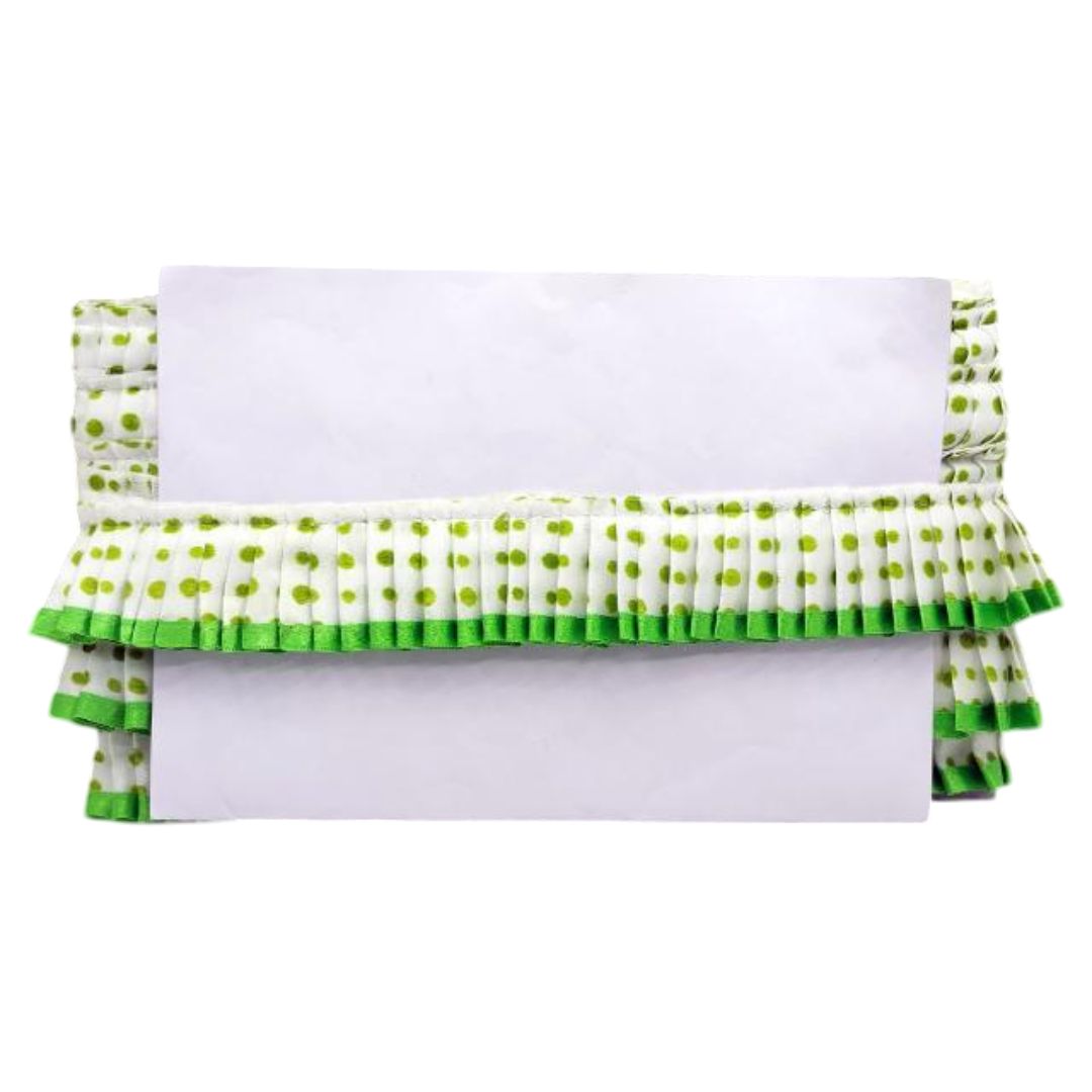 White clutch with green polka dot ruffles on a white background