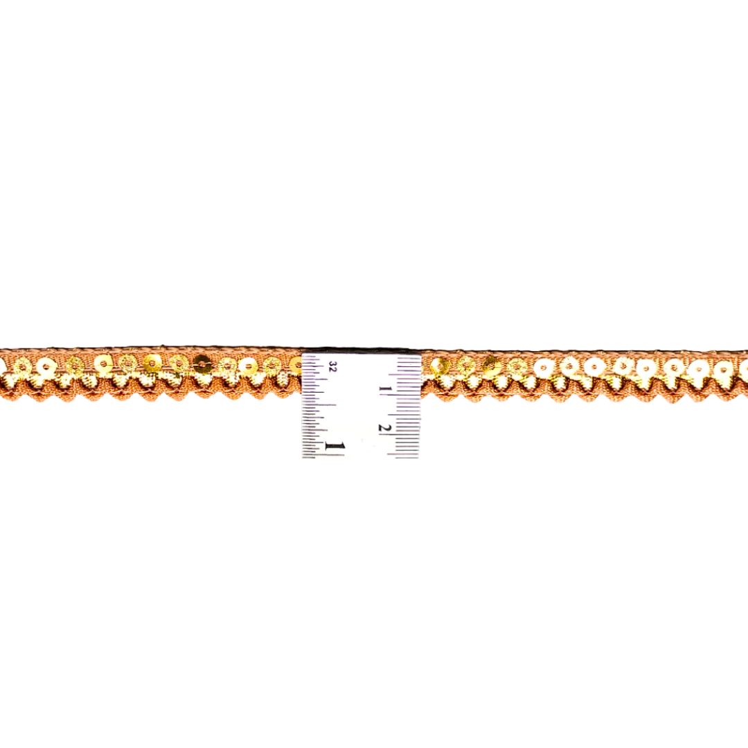 Gold lace trim with a ruler for scale on a white background