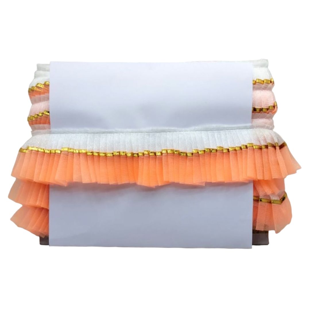 Decorative table cover with orange ruffles and gold trim on a white background
