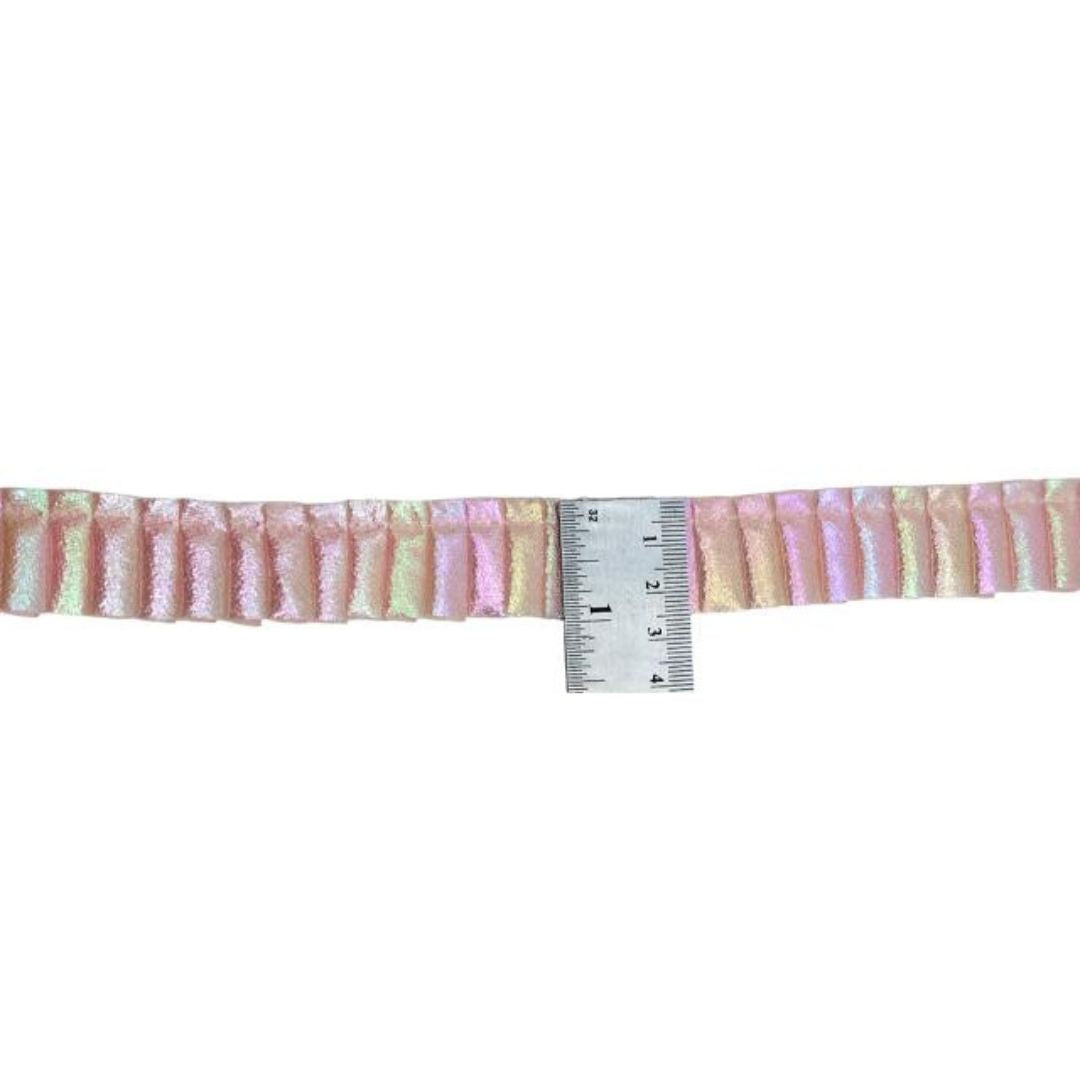 Strip of pink and yellow striped fabric with a ruler for scale on a white background