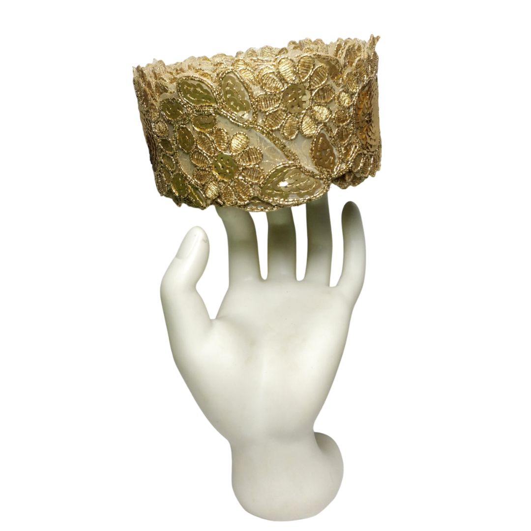 Gold lace headband on a white mannequin head with a white background