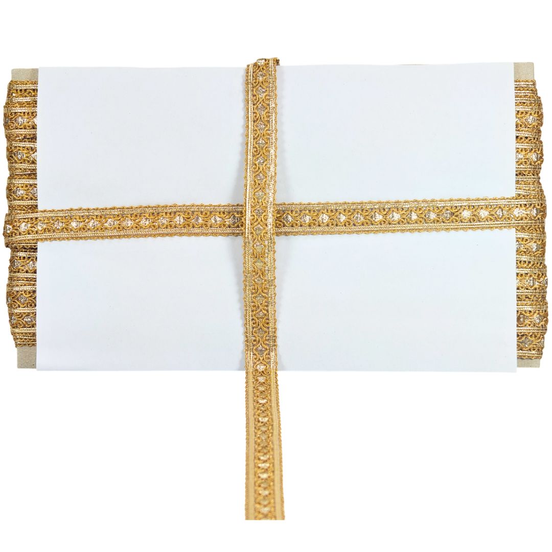 White pillow with gold decorative trim on a white background