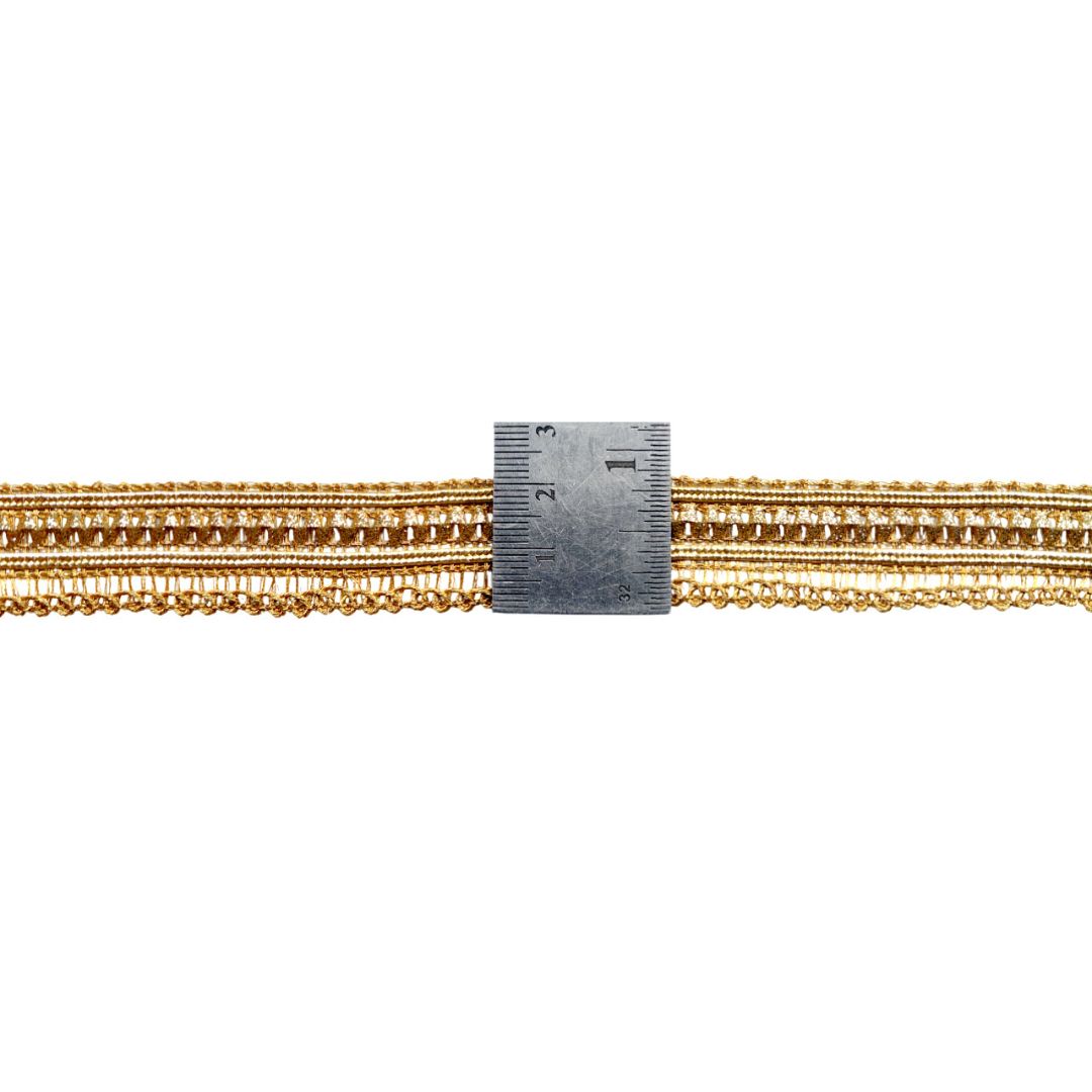 Gold chain with a ruler for scale on a white background