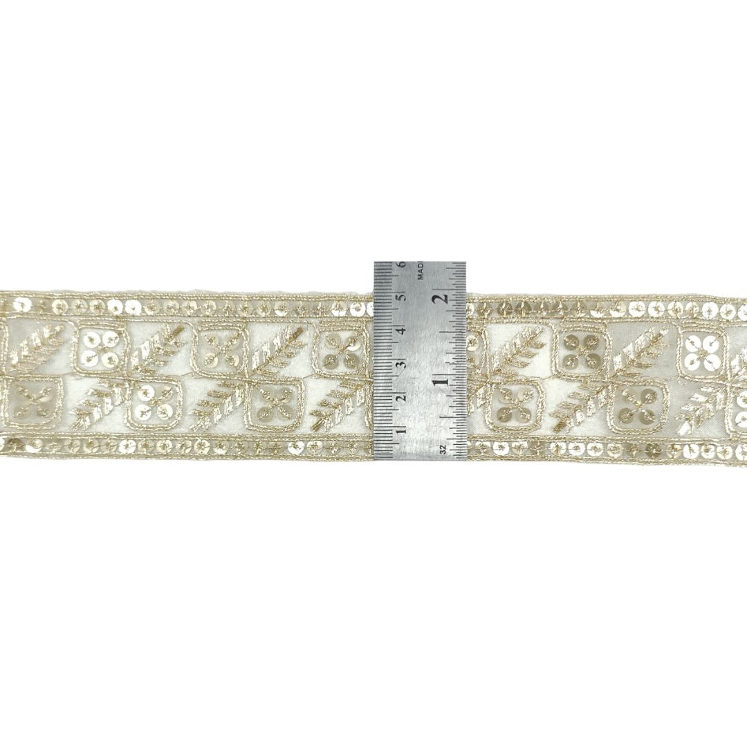 Decorative lace trim with a ruler for scale on a white background