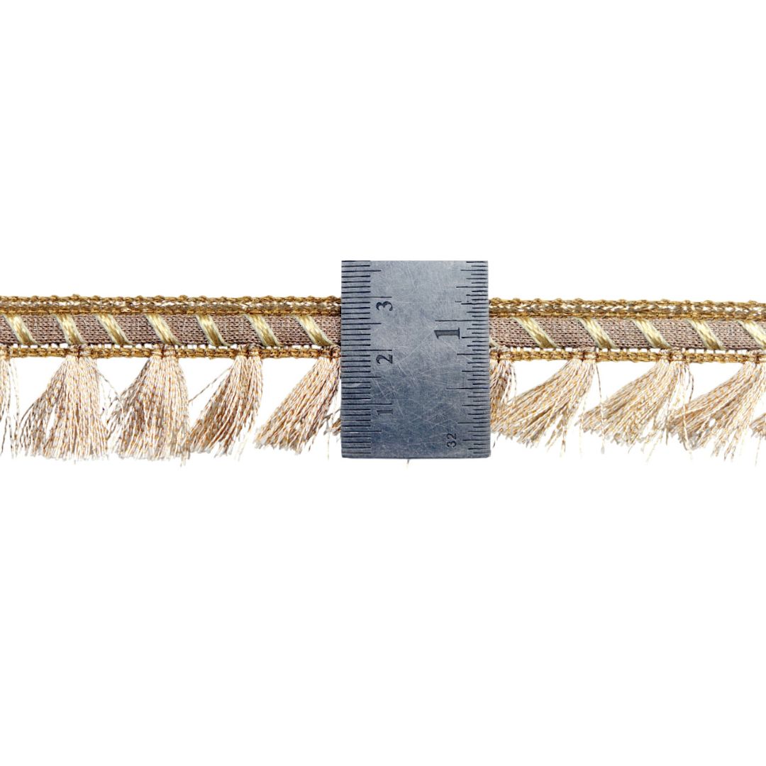 Decorative trim with tassels and a ruler for scale on a white background