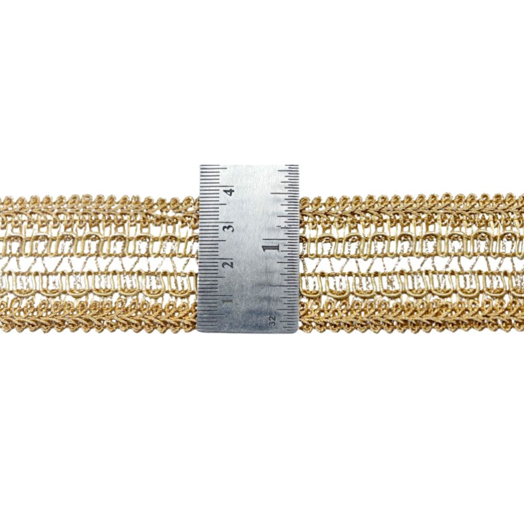 Gold chain with a ruler for scale on a white background