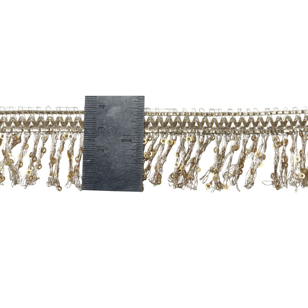 Decorative trim with beads and a ruler for scale on a white background