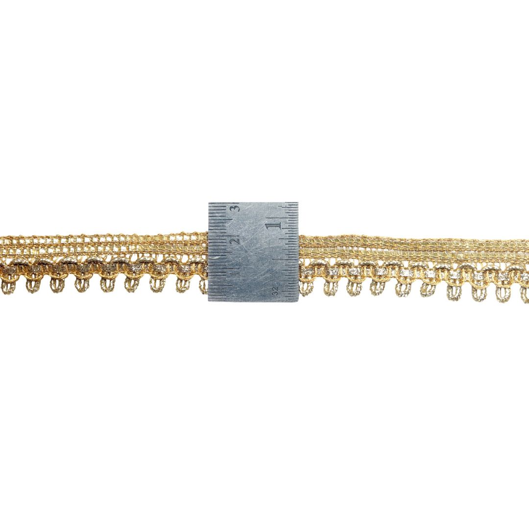 Gold fringe trim with a ruler for scale on a white background