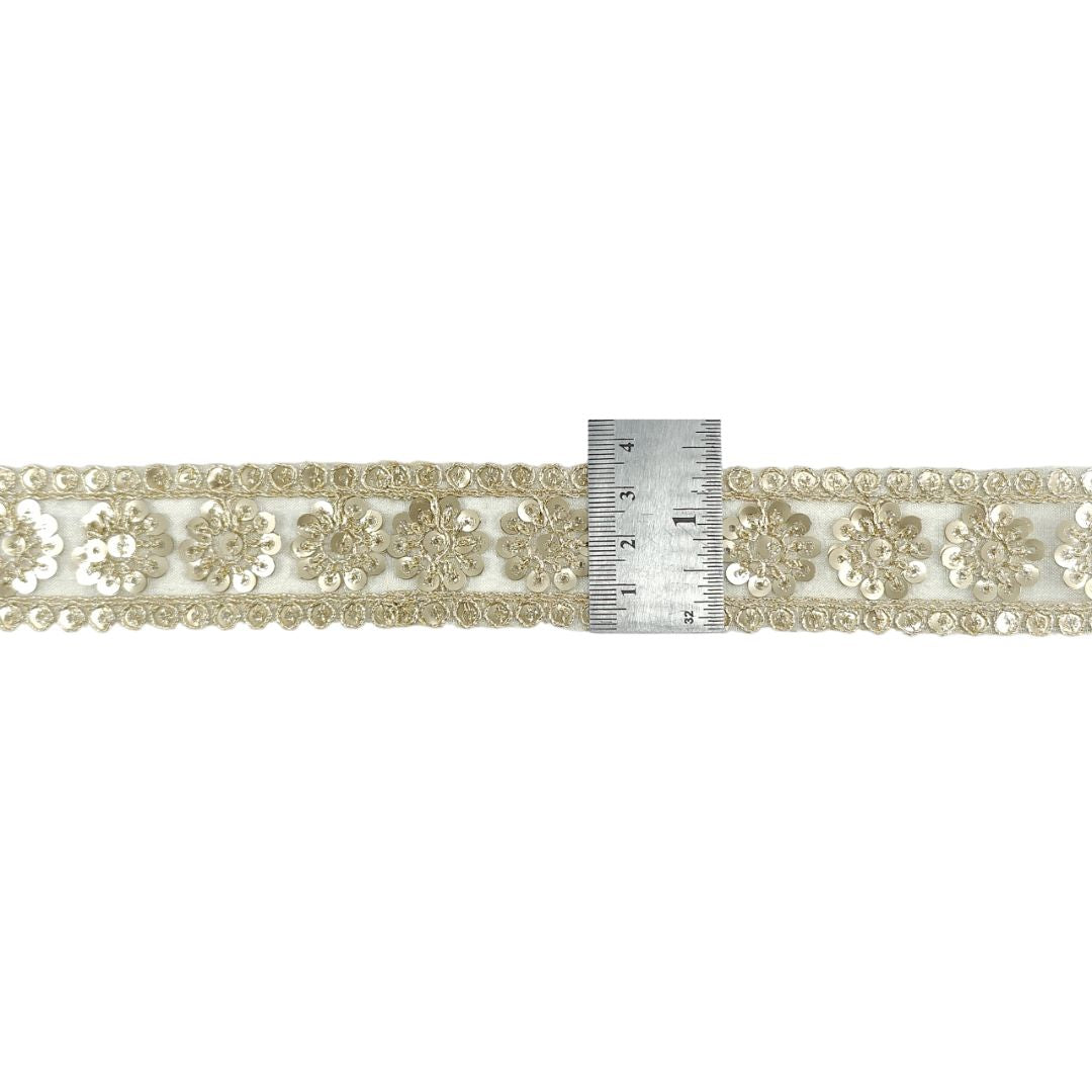 Decorative lace ribbon with a ruler for scale on a white background