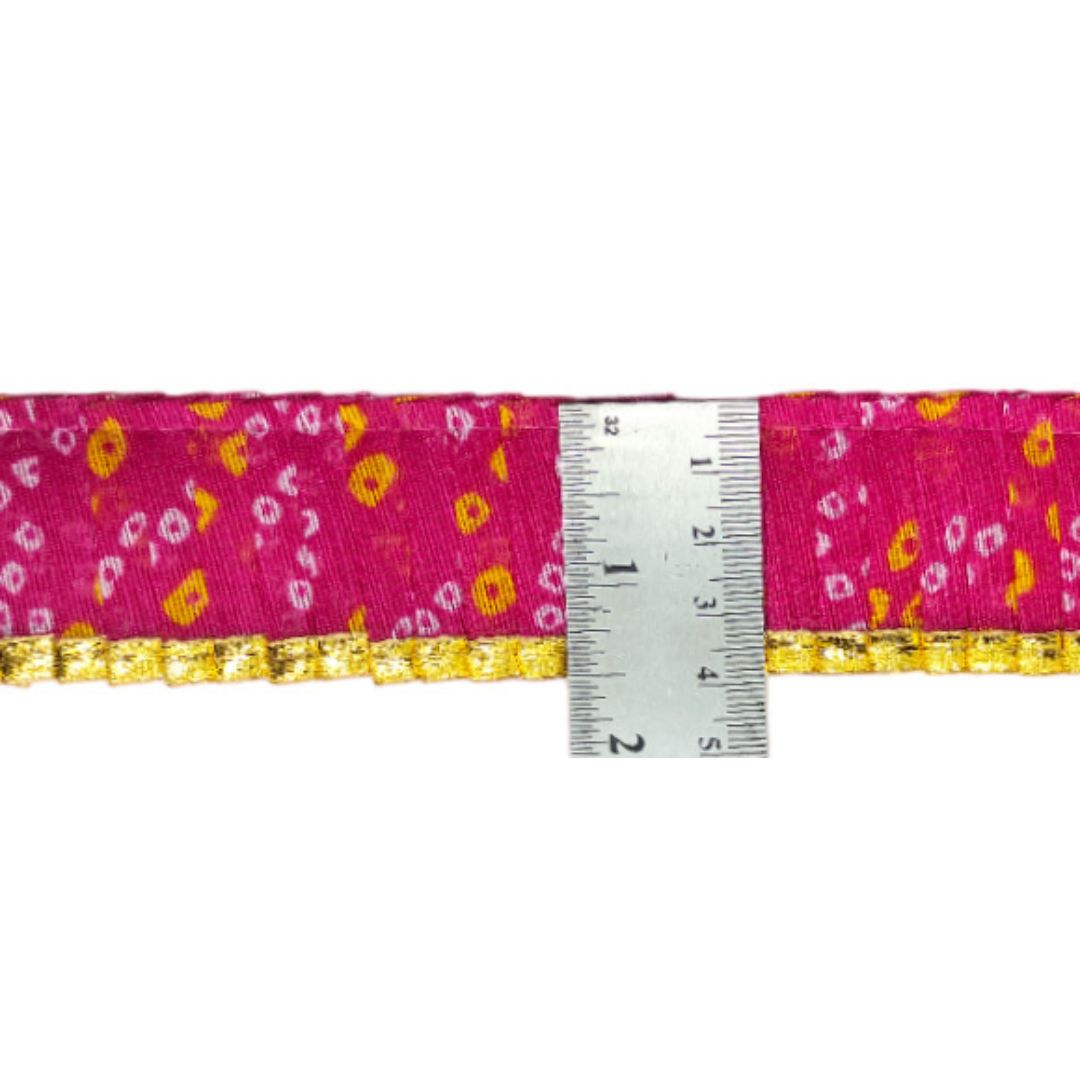 Pink ribbon with yellow floral pattern and gold trim, measured against a white background