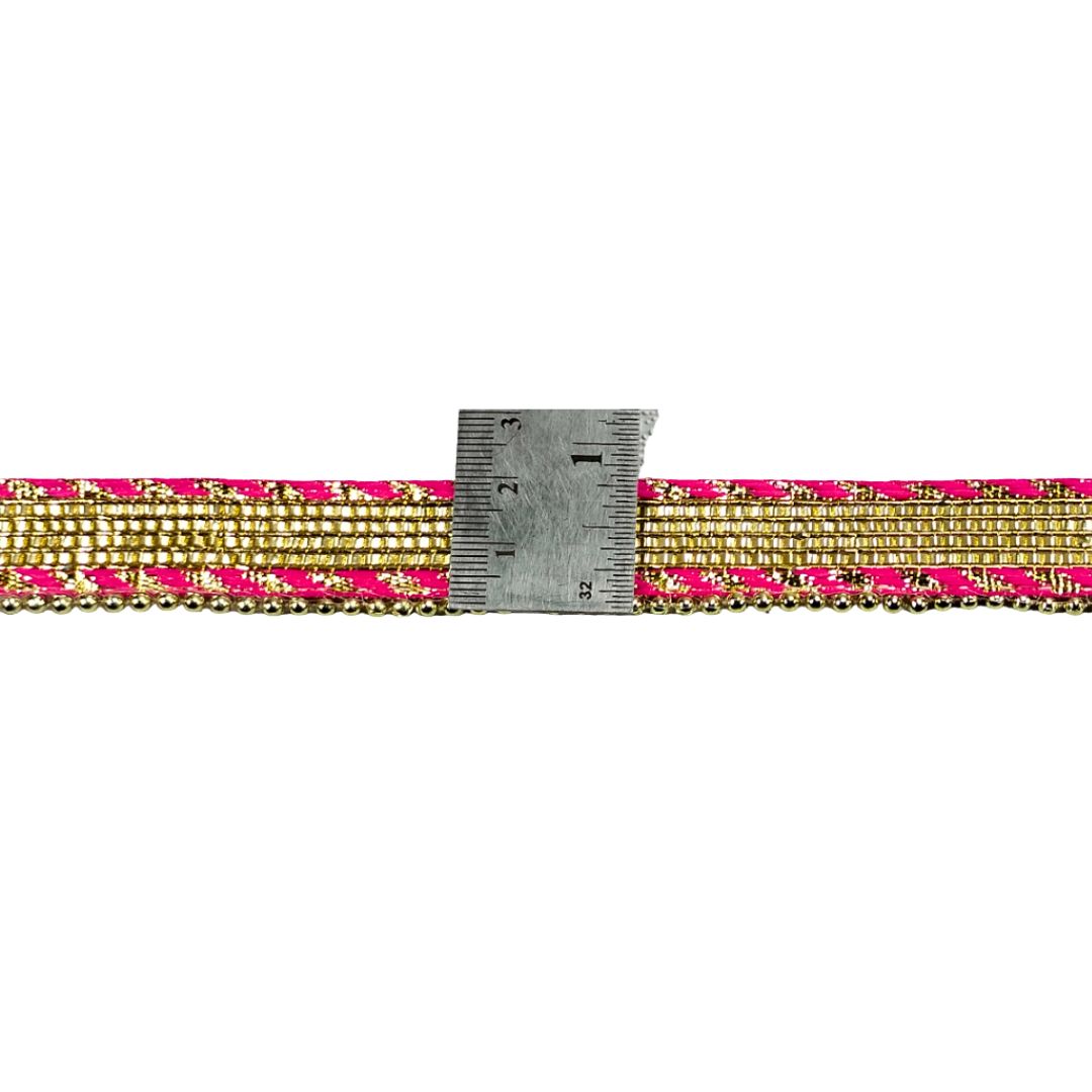 Gold and pink beaded strip with a ruler for scale on a white background