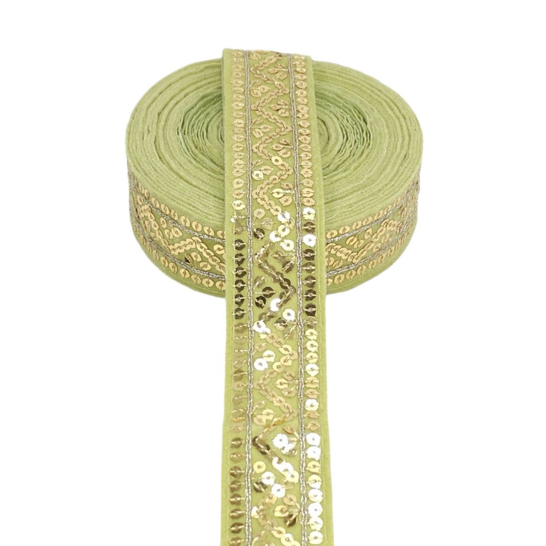 Green ribbon with gold and silver sequin detailing on a white background