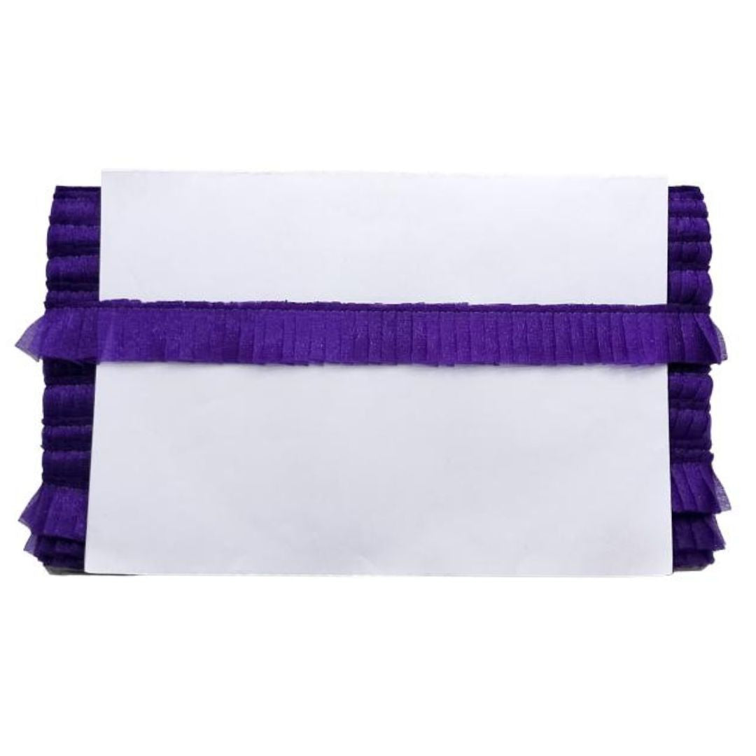 White clutch with purple ruffles on a white background
