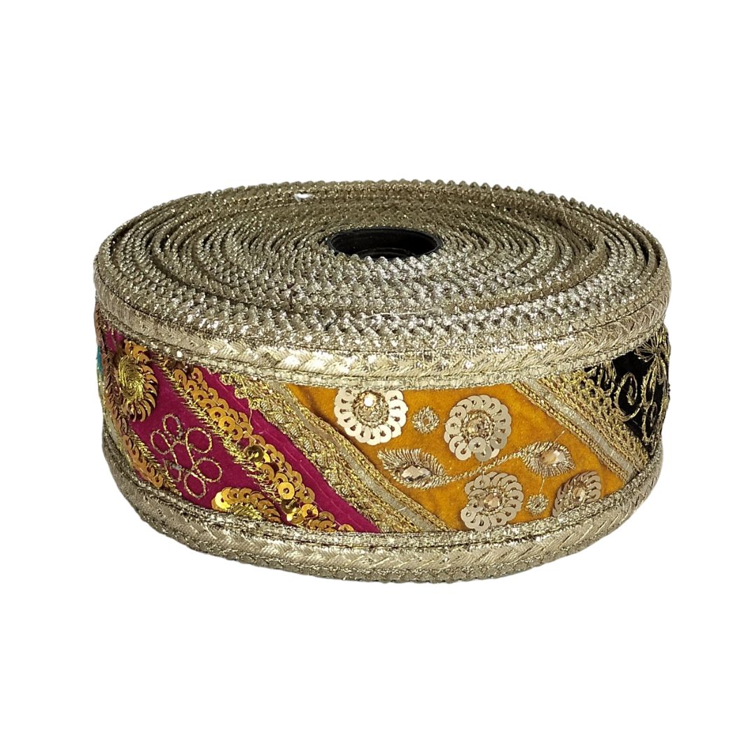 Roll of decorative ribbon with gold, pink, and yellow patterns on a white background