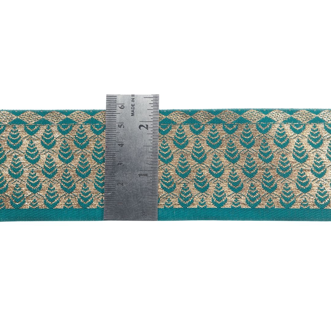 Teal and gold patterned fabric with a ruler for scale on a white background