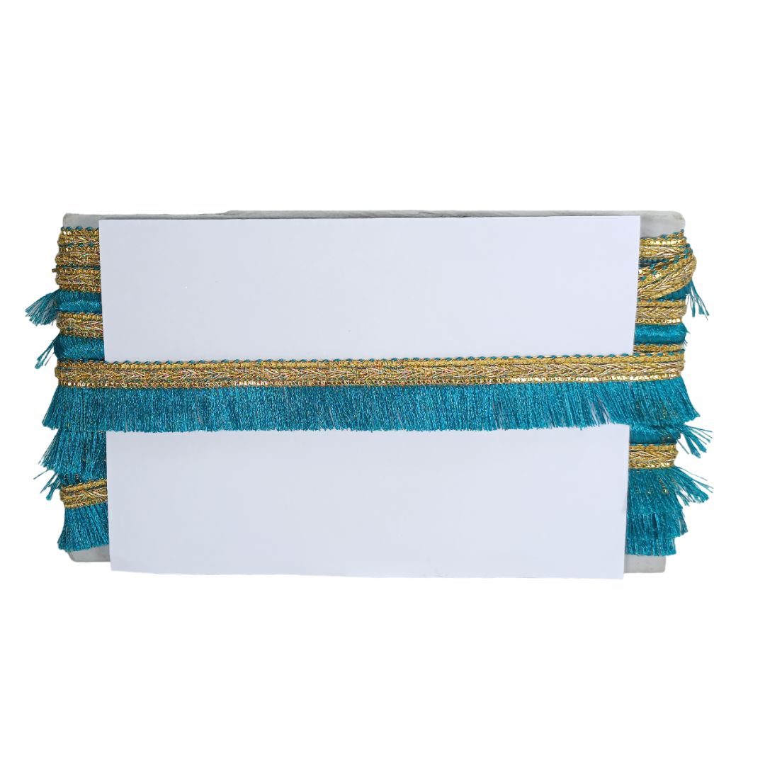 White clutch bag with gold and teal fringe on a white background