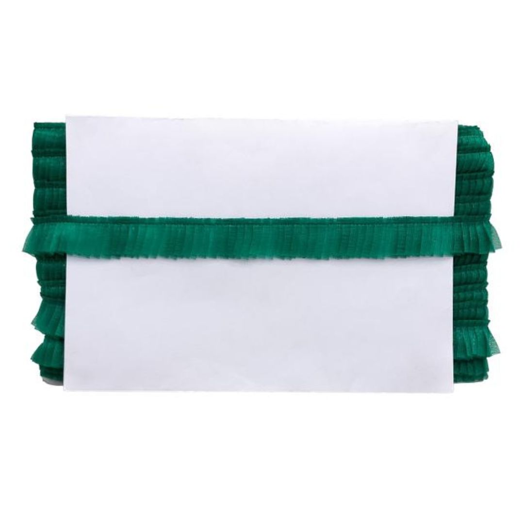 White blanket with green ruffled edges on a white background