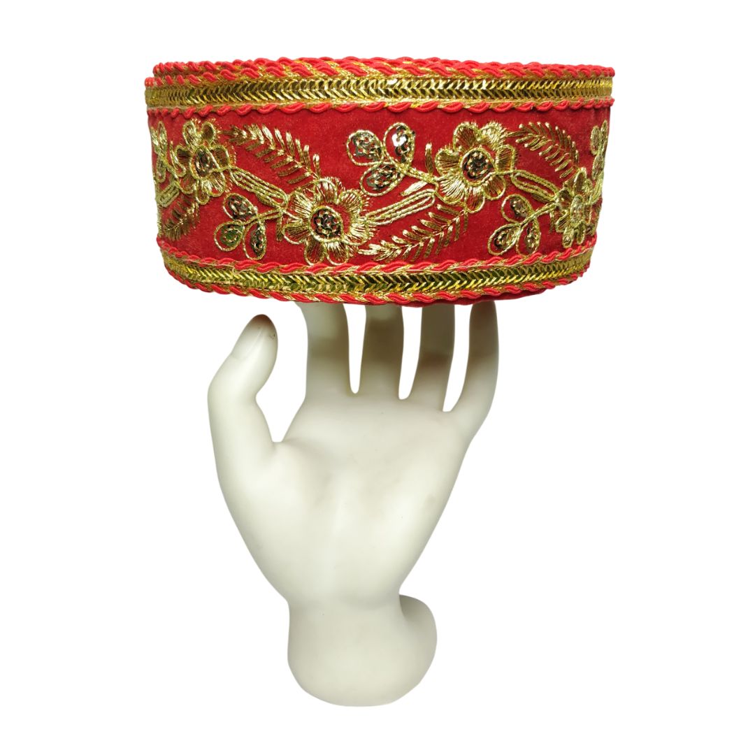 Decorative red headband with gold embroidery on a white mannequin hand