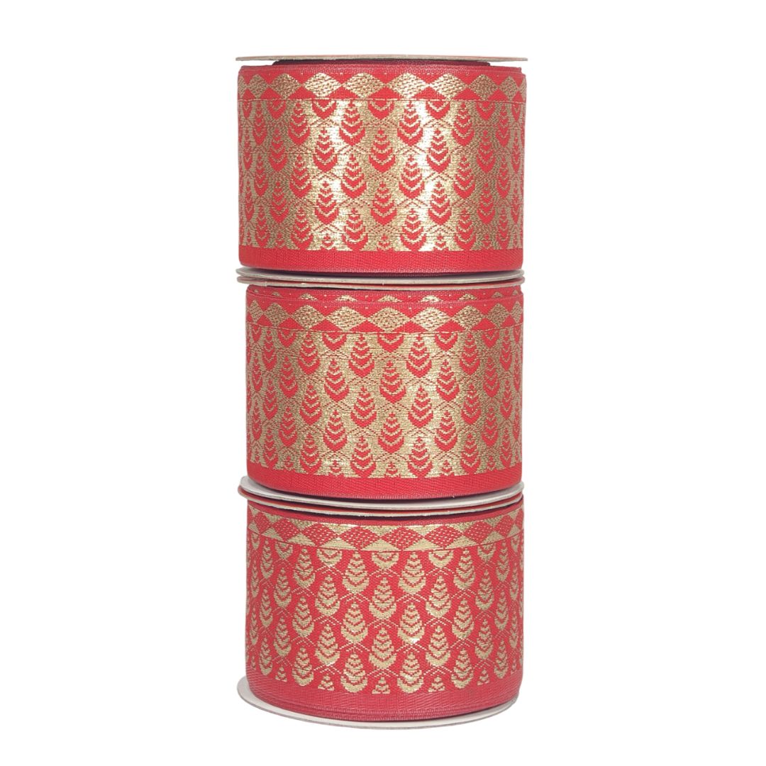 Three cylindrical red ribbons with gold patterns stacked on a white background