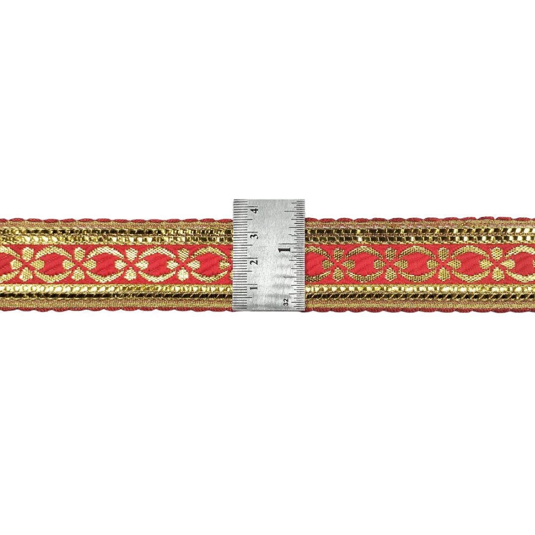 Red and gold ribbon with a ruler for scale on a white background
