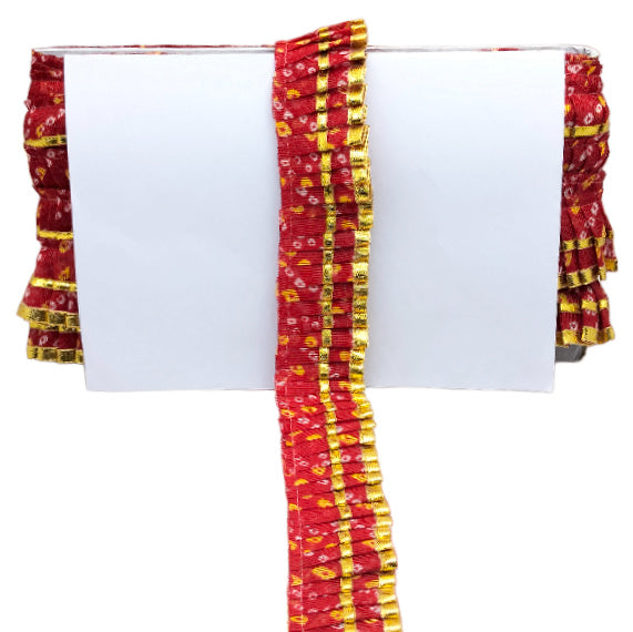 Red and yellow patterned fabric draped over a white surface