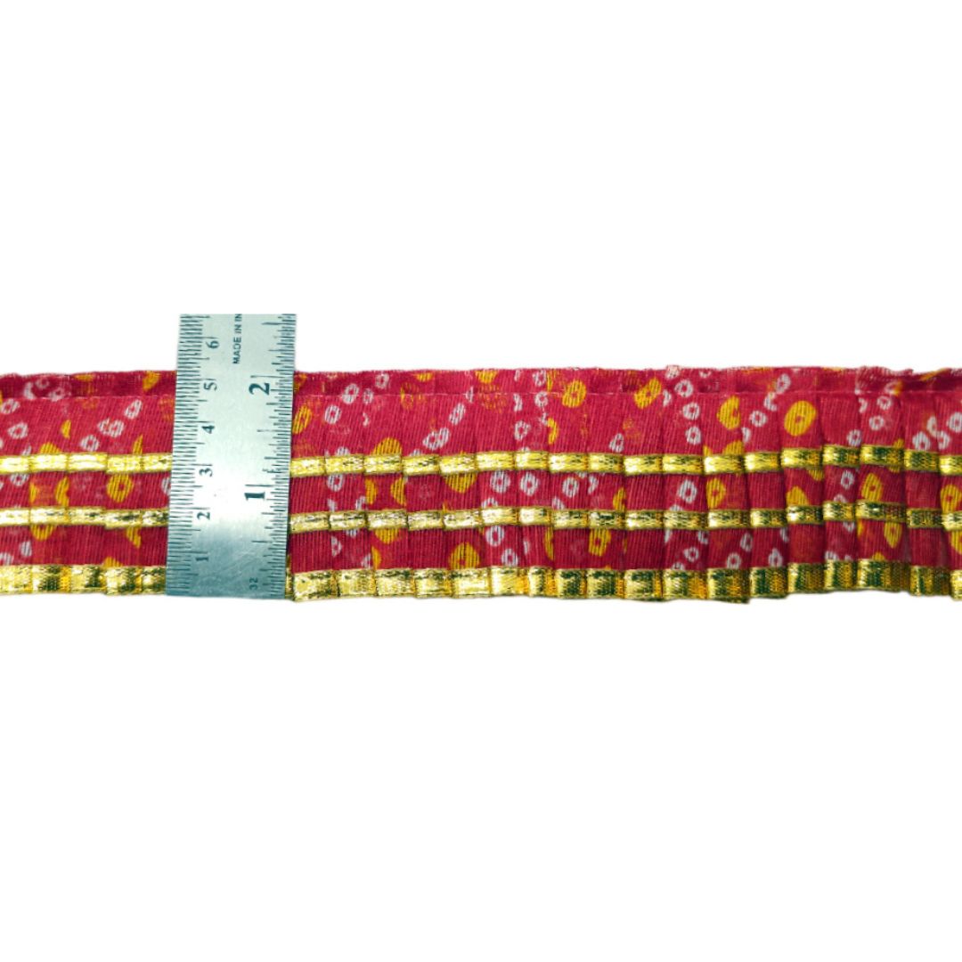 Red belt with floral pattern and a ruler for scale on a white background