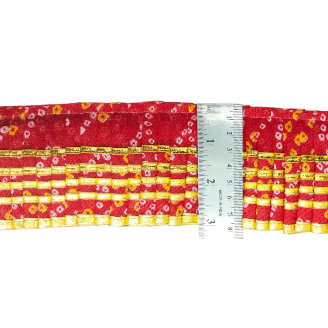 Red and yellow patterned fabric with a ruler for scale on a white background