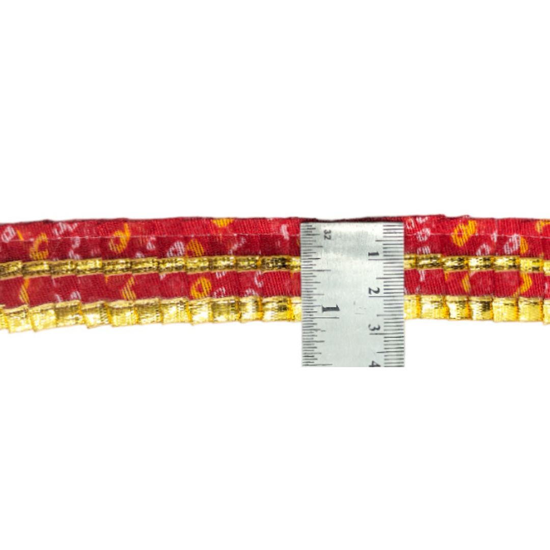 Red and gold belt with a ruler for size reference on a white background