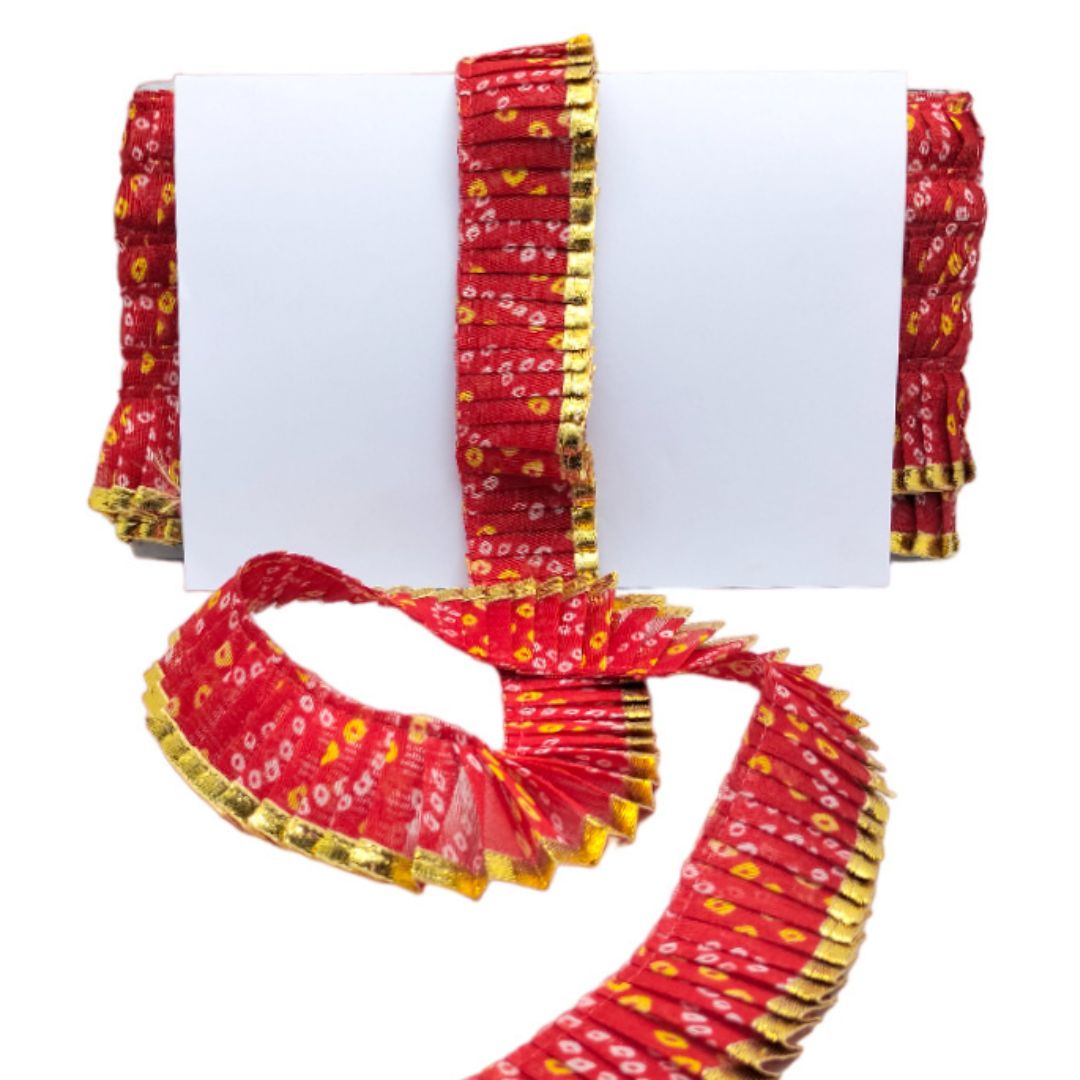 Red and gold patterned scarf with matching bangles on a white background