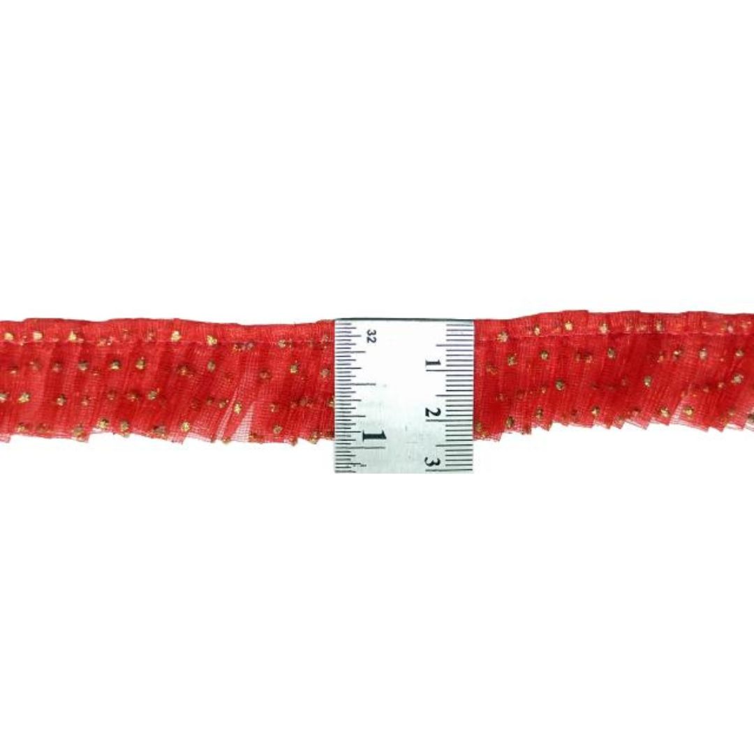Red decorative trim with gold beads measured against a ruler on a white background