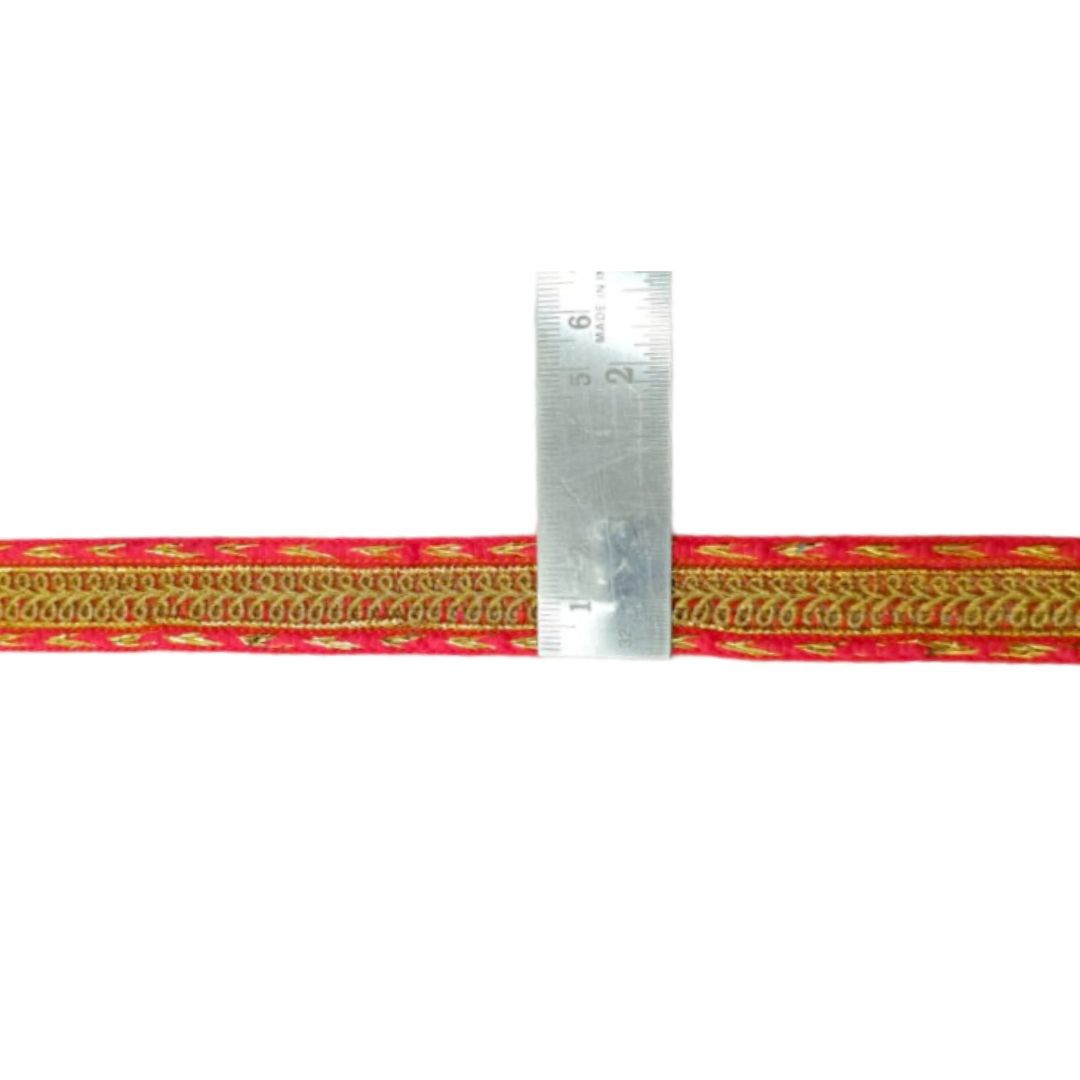 Red and gold braided cord with a ruler for scale on a white background