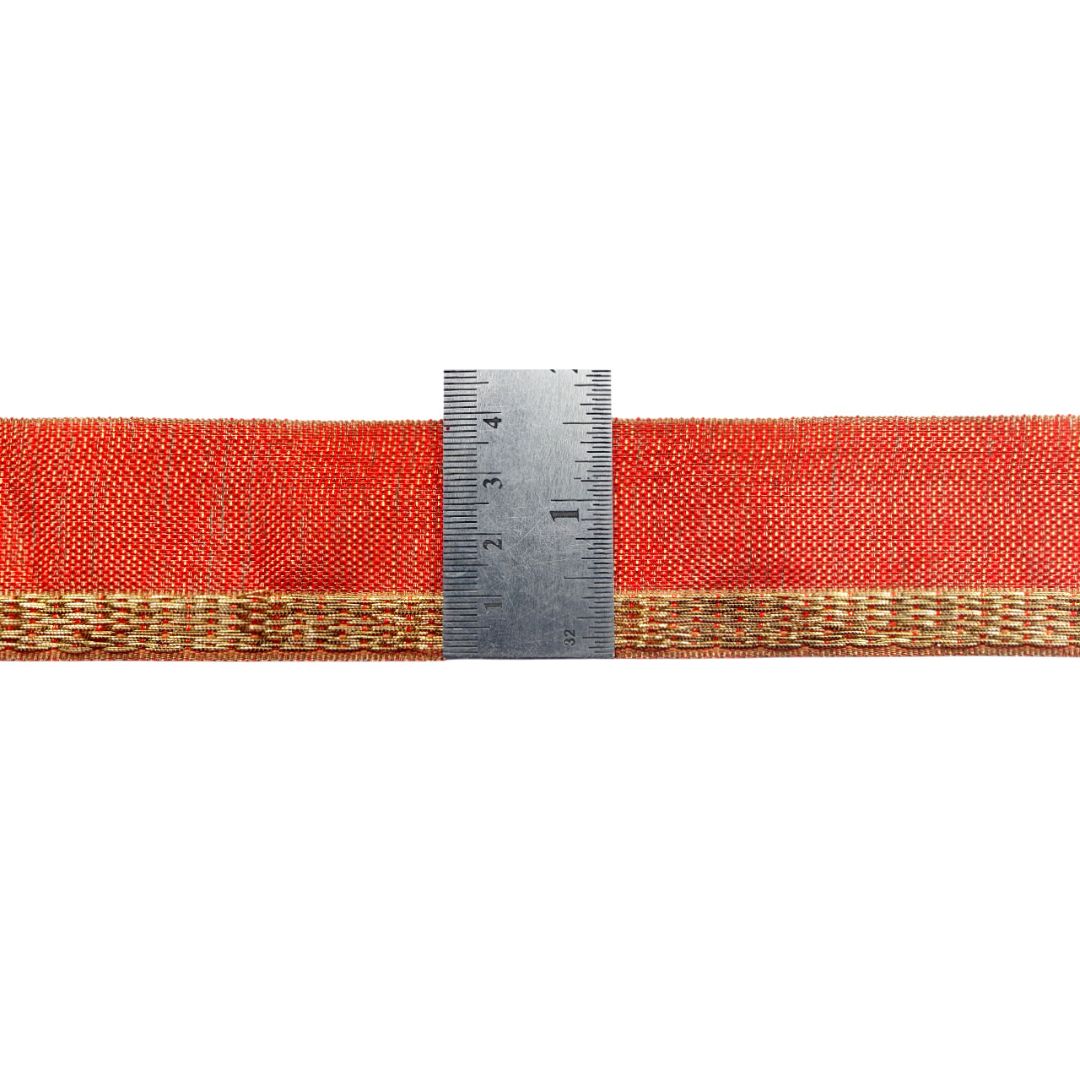 Red belt with gold edge and a ruler for scale on a white background