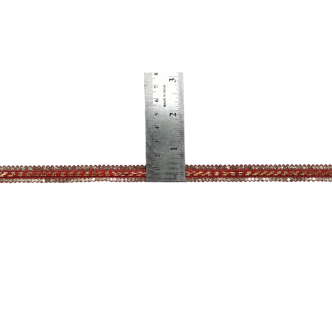 Red lace trim with a metal ruler for measurement on a white background