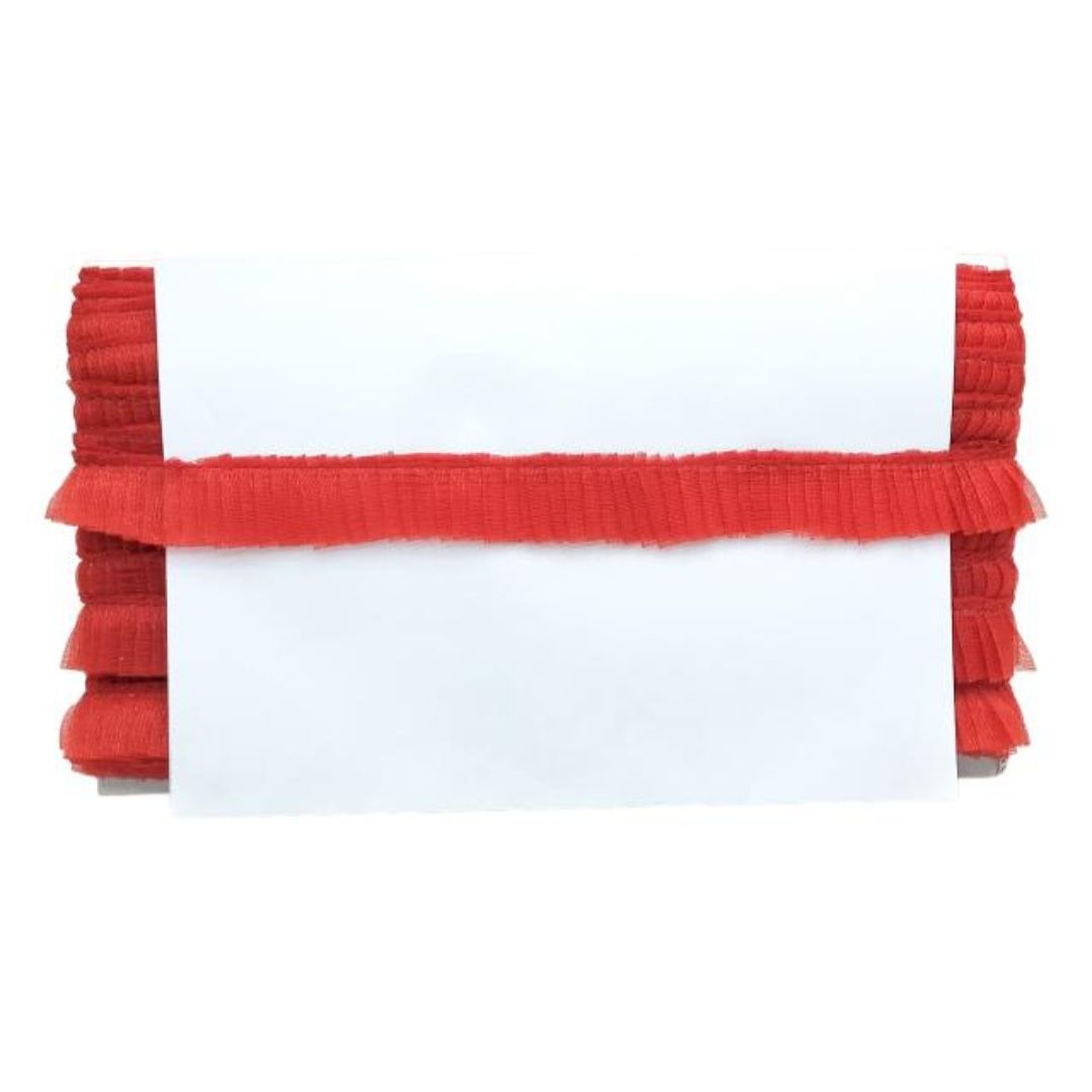 White pillow with red ruffled trim on a white background