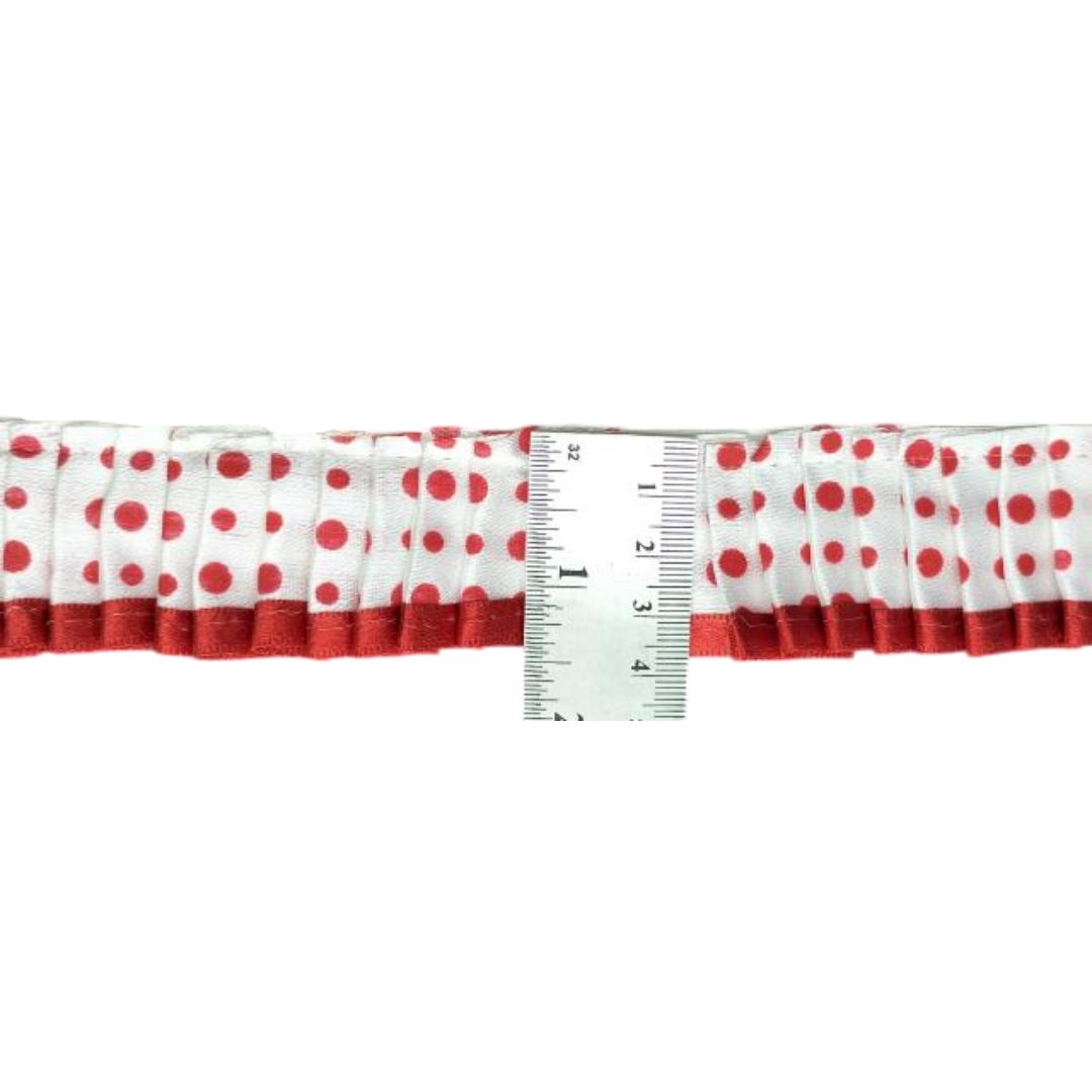 Red and white polka dot ribbon with a ruler for measurement on a white background