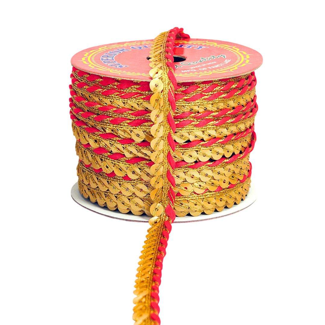 Spool of gold and red sequined ribbon on a white background